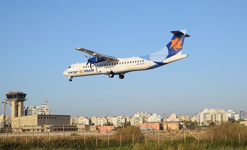 An Israir turboprop on final approach over Sde Dov with the control tower behind